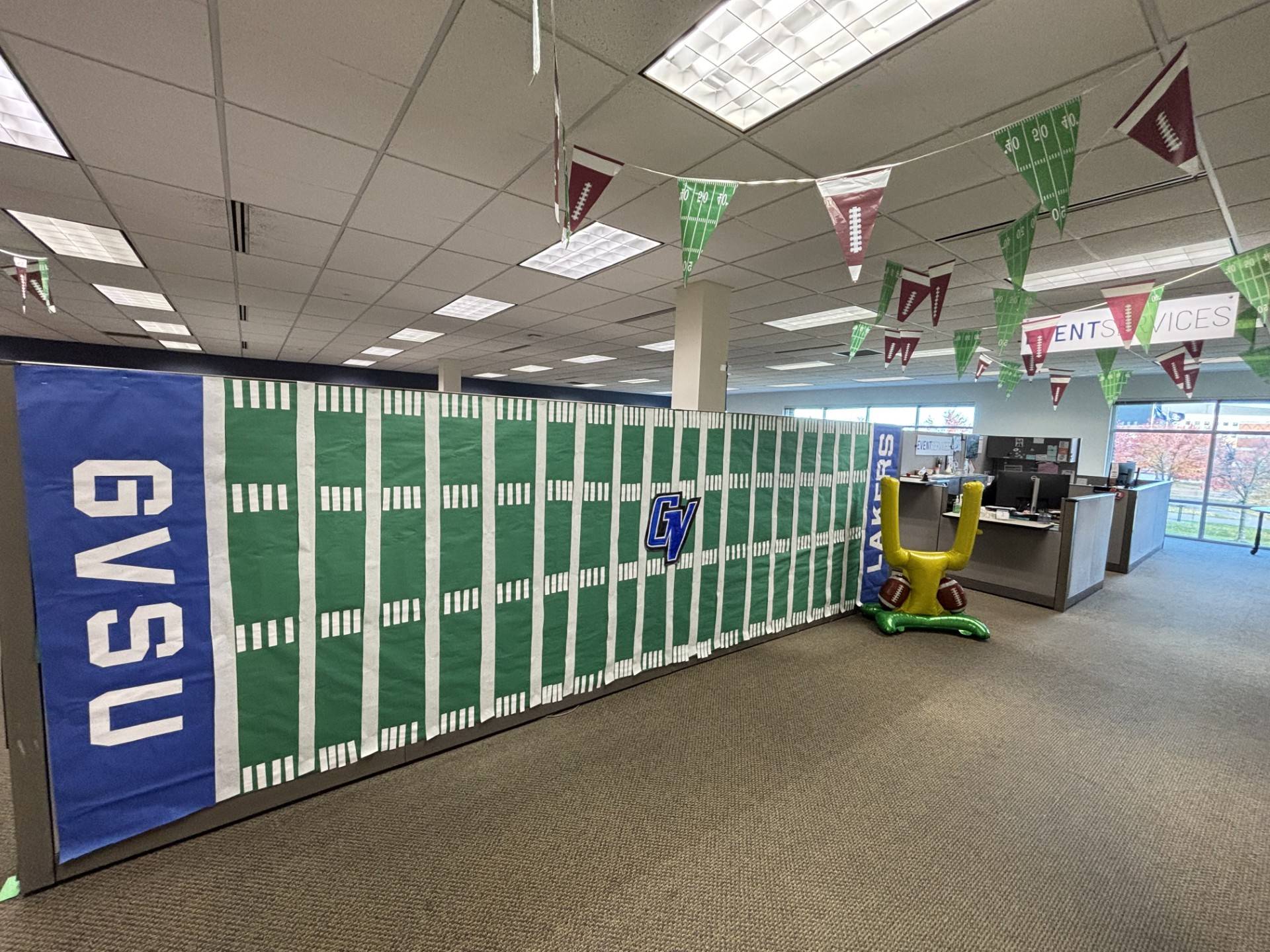 OSL Homecoming decorating with a paper football field covering a cubicle wall